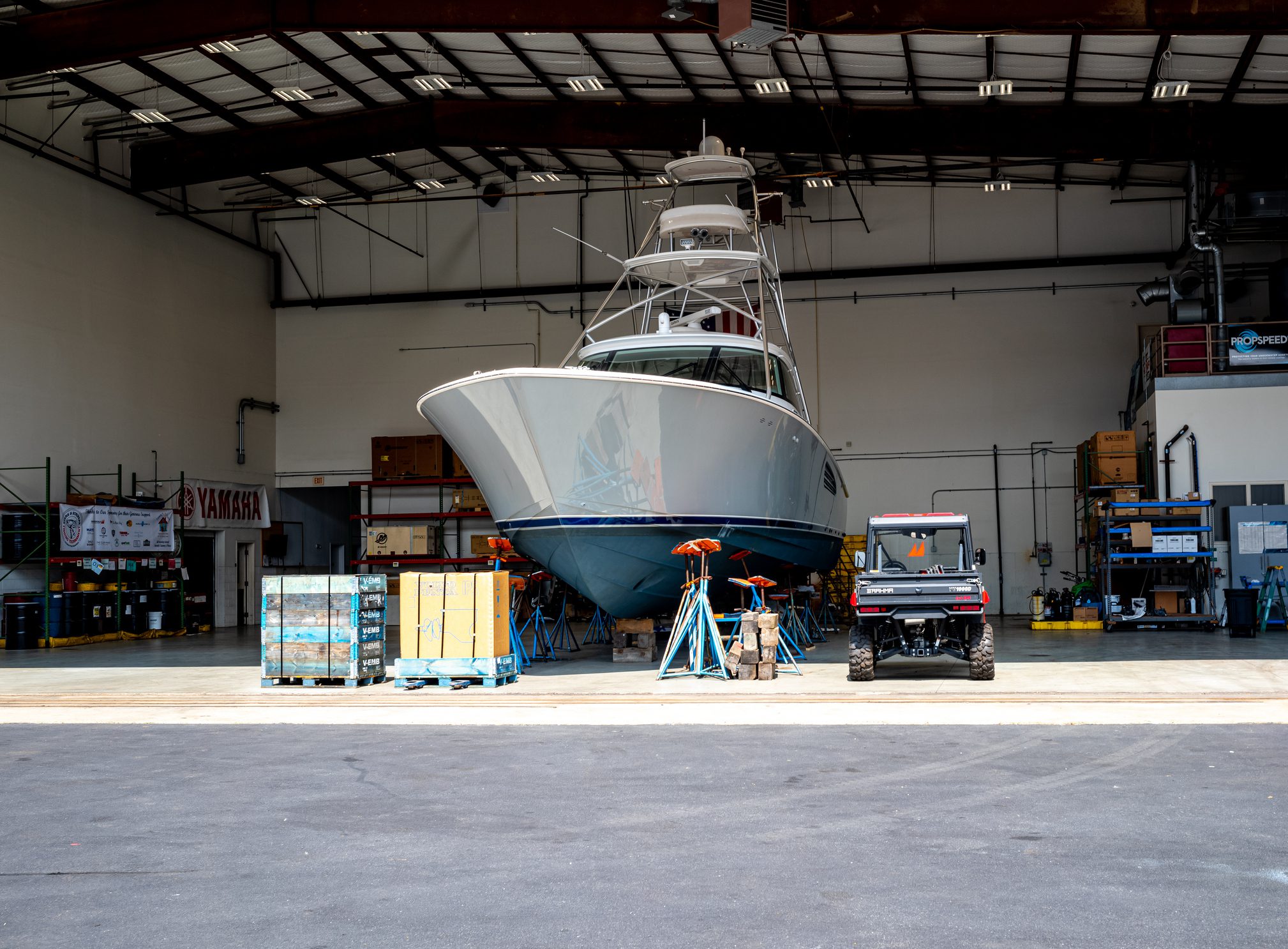 A large boat inside a warehouse undergoing maintenance.